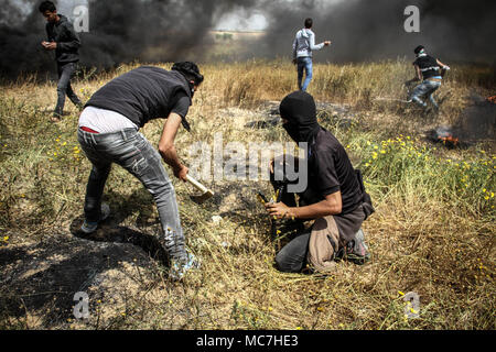 Khan Younis, dans la bande de Gaza, territoire palestinien occupé. 30Th Mar, 2018. Des manifestants palestiniens prendre part à des affrontements avec les troupes israéliennes à la frontière dans l'est de Gaza avec Israël, à l'est de Khan Younis City, le 30 mars 2018. Des dizaines de Palestiniens ont été blessés dans des affrontements vendredi entre manifestants et soldats israéliens à l'est de la bande de Gaza, selon des témoins et les ambulanciers. Credit : Ahmad Salem/ZUMA/Alamy Fil Live News Banque D'Images