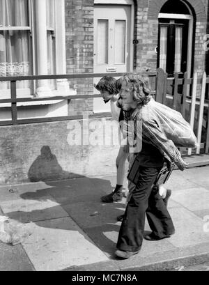 Les jeunes garçons la collecte de bouteilles en verre pour recueillir le dépôt et de faire un peu d'argent de poche dans le sud de Londres 1970 Banque D'Images