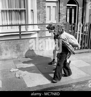 Les jeunes garçons la collecte de bouteilles en verre pour recueillir le dépôt et de faire un peu d'argent de poche dans le sud de Londres 1970 Banque D'Images