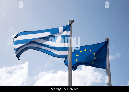 L'Union européenne et des drapeaux grecs battant côte à côte de mâts against a blue sky Banque D'Images