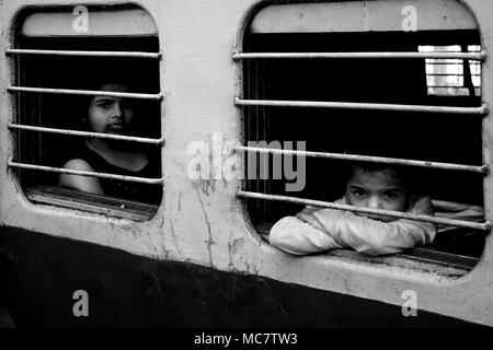 Fille et garçon sur le site de la fenêtre d'un train indien, Mumbai lié. Noir et blanc. Banque D'Images