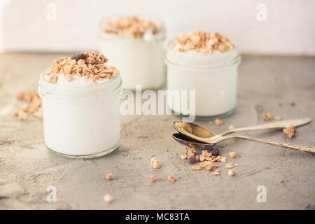 Yaourt au muesli fait d'avoine, raisins secs, riz soufflé, de chocolat et de bananes séchées. Petit-déjeuner sain pour la famille. Alimentaire sain. Banque D'Images