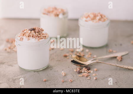 Yaourt au muesli fait d'avoine, raisins secs, riz soufflé, de chocolat et de bananes séchées. Petit-déjeuner sain pour la famille. Alimentaire sain. Banque D'Images