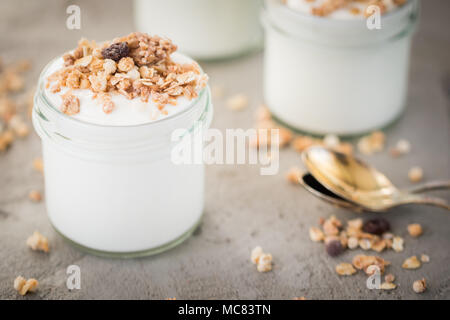 Yaourt au muesli fait d'avoine, raisins secs, riz soufflé, de chocolat et de bananes séchées. Petit-déjeuner sain pour la famille. Alimentaire sain. Banque D'Images