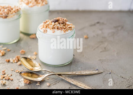 Yaourt au muesli fait d'avoine, raisins secs, riz soufflé, de chocolat et de bananes séchées. Petit-déjeuner sain pour la famille. Alimentaire sain. Banque D'Images