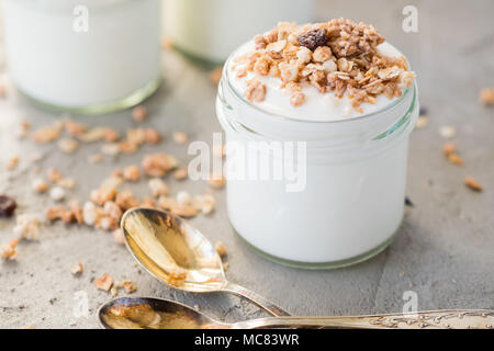 Yaourt au muesli fait d'avoine, raisins secs, riz soufflé, de chocolat et de bananes séchées. Petit-déjeuner sain pour la famille. Alimentaire sain. Banque D'Images