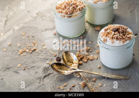 Yaourt au muesli fait d'avoine, raisins secs, riz soufflé, de chocolat et de bananes séchées. Petit-déjeuner sain pour la famille. Alimentaire sain. Banque D'Images