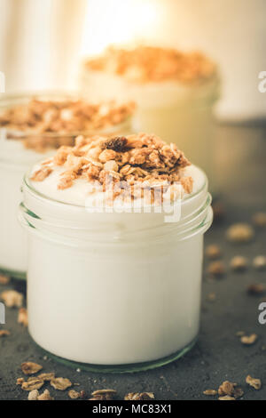 Yaourt au muesli fait d'avoine, raisins secs, riz soufflé, de chocolat et de bananes séchées. Petit-déjeuner sain pour la famille. Alimentaire sain. Banque D'Images