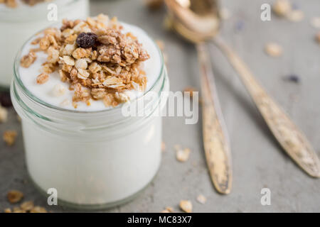 Yaourt au muesli fait d'avoine, raisins secs, riz soufflé, de chocolat et de bananes séchées. Petit-déjeuner sain pour la famille. Alimentaire sain. Banque D'Images