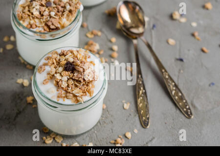 Yaourt au muesli fait d'avoine, raisins secs, riz soufflé, de chocolat et de bananes séchées. Petit-déjeuner sain pour la famille. Alimentaire sain. Banque D'Images