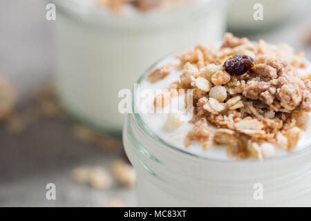 Yaourt au muesli fait d'avoine, raisins secs, riz soufflé, de chocolat et de bananes séchées. Petit-déjeuner sain pour la famille. Alimentaire sain. Banque D'Images