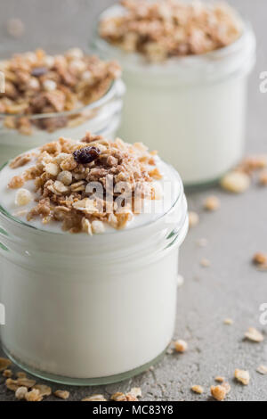 Yaourt au muesli fait d'avoine, raisins secs, riz soufflé, de chocolat et de bananes séchées. Petit-déjeuner sain pour la famille. Alimentaire sain. Banque D'Images