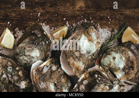 Oyster shell ouvert avec le citron et le sel sur une planche en bois Banque D'Images