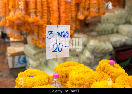 Tagètes oranges et jaunes en vente pour utilisation dans les offres hindou dans il marché aux fleurs Bangkok Thaïlande Banque D'Images