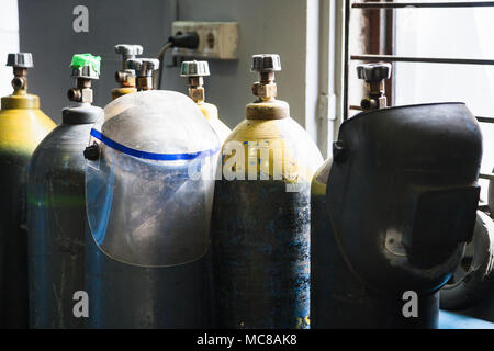 Les bouteilles de gaz et les masques de protection soudeur en atelier Banque D'Images