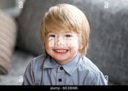 Head shot of cute little boy, heureux enfant drôle avec les cheveux de lumière blonde looking at camera, adorable Enfant gaie positive avec visage souriant posant à ho Banque D'Images