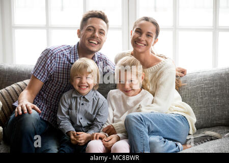 Portrait de famille multinationale heureux avec les enfants adoptés de rire ensemble, de collage smiling young couple embracing boy fils et fille fille assise o Banque D'Images