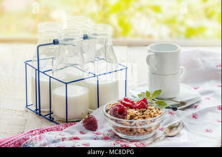 Un petit-déjeuner sain avec le muesli, de framboise et de fruits frais est servi sur une table en bois. La structure horizontale. Banque D'Images