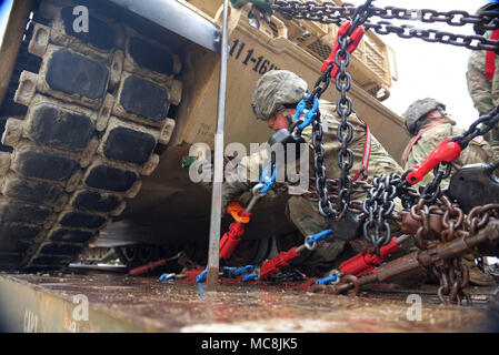 La CPS. Arizona Poe, M1 armor crewman attribuée à la société B, 1er Bataillon, 16e Régiment d'infanterie, 1st Armored Brigade Combat Team, 1re Division d'infanterie, resserre les chaînes d'un M1 Abrams tank à un wagon plat Le 26 mars au Camp Funston sur Fort Riley. Les soldats prêts à la tête à la Joint Readiness Training Center à Fort Polk, en Louisiane, dans le cadre d'un exercice de préparation au déploiement d'urgence. (Le s.. Elizabeth Tarr, 1er ABCT Affaires publiques) Banque D'Images