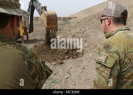 Les membres de la force de coalition watch une pelleteuse creuser des puits qui seront utilisés par les membres du Service de lutte contre le terrorisme au cours de la formation des explosifs à Bagdad, l'Iraq, le 28 mars 2018. La Coalition continuera de se tenir aux côtés de nos partenaires irakiens pour assurer la défaite de l'ISIS. Banque D'Images