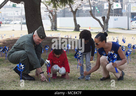 Le Lieutenant-colonel du Corps des Marines américain John Harris, à gauche, de la direction de Marine Corps Air Station (MCAS Iwakuni), plantes pinwheels avec Matthew C. Perry les élèves du primaire au cours de la nationale 2018 La prévention de la violence à l'ensemencement à moulinet MCAS Iwakuni, Japon, le 29 mars 2018. Le bleu roulades ont été plantés dans le cadre du Programme national de prévention de l'abus des mois d'activités et d'offrir l'occasion pour les particuliers et les organisations à prendre des mesures. Banque D'Images