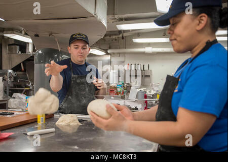 Océan Atlantique (31 mars 2018) 2e classe spécialiste culinaire Tyler Silva, à partir de la kuna, Idaho, lance une boule de pâte à pizza pour être roulée dans la préparation de Pizza samedi soir à bord du porte-avions USS George H. W. Bush (CVN 77). Le navire est en cours d'exercices de soutien pour maintenir l'état de préparation de l'opérateur. Banque D'Images