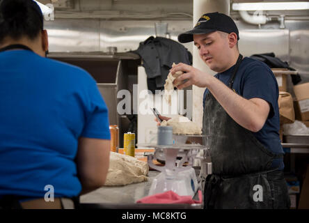 Océan Atlantique (31 mars 2018) 2e classe spécialiste culinaire Tyler Silva, à partir de la kuna, Idaho, pèse la pâte à pizza dans la préparation de Pizza samedi soir à bord du porte-avions USS George H. W. Bush (CVN 77). Le navire est en cours d'exercices de soutien pour maintenir l'état de préparation de l'opérateur. Banque D'Images