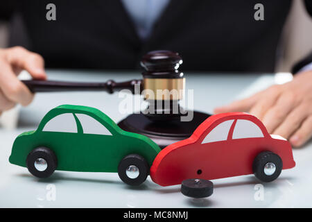 Close-up of Accident de voiture rouge et vert en face du juge Holding Gavel Banque D'Images