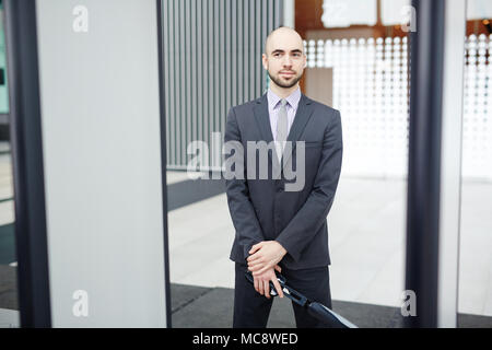 Garde de l'aéroport avec détecteur de métal debout par des portes à l'entrée de l'aéroport Banque D'Images