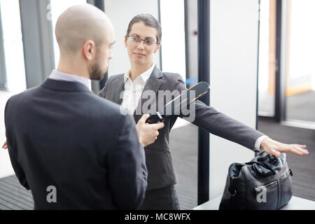 Garde de sécurité contemporaine avec détecteur de métal contrôle de l'un des passagers sur l'aéroport d'entrée Banque D'Images