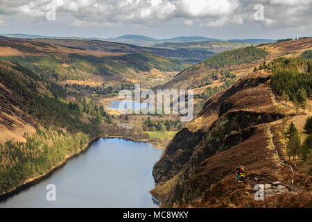 Deux randonnées à la Spinc ridge admirant la vue spectaculaire de la vallée de Glendalough avec les lacs supérieur et inférieur et le site monastique dans l'arrière-plan. Banque D'Images