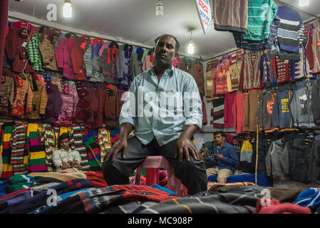 Un vendeur du kiosque de vêtements assis dans son magasin à Sonepur, Inde. 8 novembre 2017 Banque D'Images