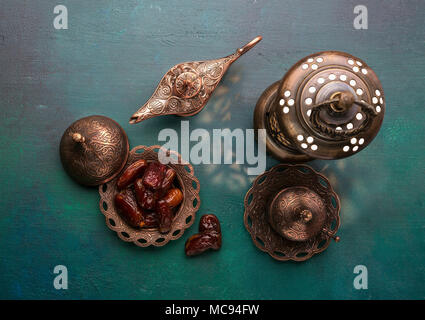 Plaque de bronze avec les dates, tasse de café, l'arabe et lanterne lampe aladdin vert foncé sur fond de bois. Ramadan kareem. Ramadan arrière-plan. Mise à plat. Banque D'Images