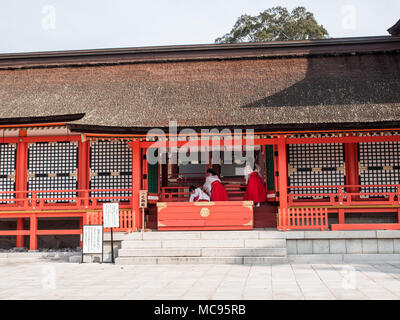 Miko, culte Maidens nettoyage du Haiden, temple principal, Jogu, Usa Jingu, Oita, Kyushu, Japon Banque D'Images