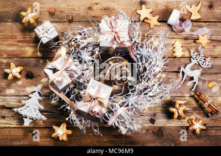 Couronne de Noël avec du gingembre cookies, silver stars, cônes, de noisette, d'anis, ruban, ruban, flocons de neige, les rennes. Vue de dessus, copiez l'espace, la lumière, sno bokeh Banque D'Images