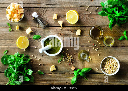 Les ingrédients pour le pesto fait maison - basilic, citron, parmesan, pignons de pin, ail, huile d'olive et de sel sur fond de bois rustique. Haut de la vue, télévision lay, copysp Banque D'Images