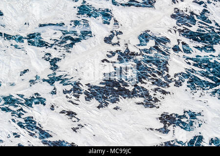 Vue aérienne d'un lac gelé dans l'Arctique montrant les patrons de la glace qui s'écaille à travers les patchs de neige, Territoires du Nord-Ouest, Canada Banque D'Images
