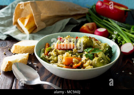 Un régime alimentaire plat végétalien : couscous et légumes (haricots verts, choux de Bruxelles, carottes, poivrons, tomates). Banque D'Images