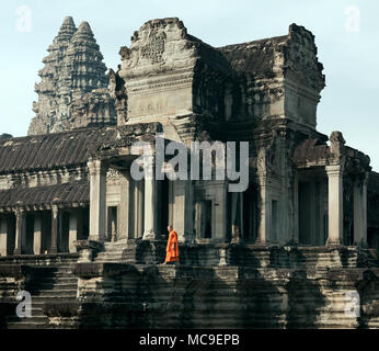 Siem Reap, Cambodge - janvier 19, 2011 : un moine dans sa robe orange marche sur la plate-forme de l'Angkor Wat complexe. Banque D'Images