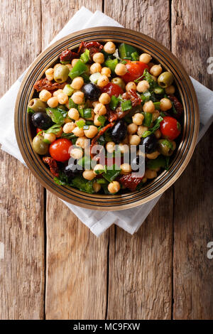 Salade de pois chiches est balela, tomates, oignons, olives et herbes gros plan sur une assiette. Haut Vertical Vue de dessus Banque D'Images