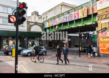 Les personnes qui traversent la route, à la jonction entre la route de l'Atlantique et Brixton Road avec vue sur le pont de Brixton avec peinture murale représentant l'installation art Banque D'Images