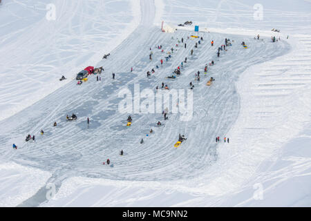 Vue aérienne des personnes participant au derby de pêche sur glace d'hiver sur le fleuve Mackenzie, dans la ville arctique d'Inuvik, Territoires du Nord-Ouest, Canada. Banque D'Images