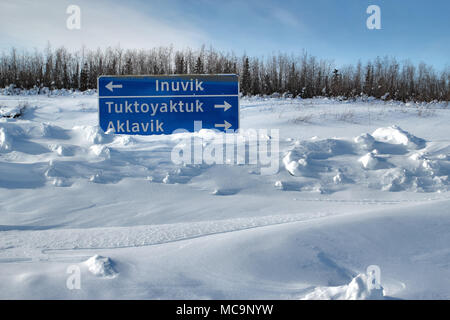 Panneau de route enfoui dans la neige, le long de la route de glace d'hiver jusqu'aux collectivités subarctiques d'Inuvik, de Tuktoyaktuk et d'Aklavik (Territoires du Nord-Ouest, Canada). Banque D'Images