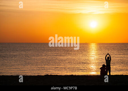 Couple sur la plage qui pose pour des photos et d'apprécier le matin sunrise en Floride Banque D'Images