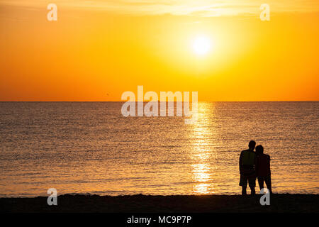 Couple sur la plage qui pose pour des photos et d'apprécier le matin sunrise en Floride Banque D'Images