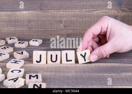 Juillet. Lettres en bois sur le bureau 24 Banque D'Images