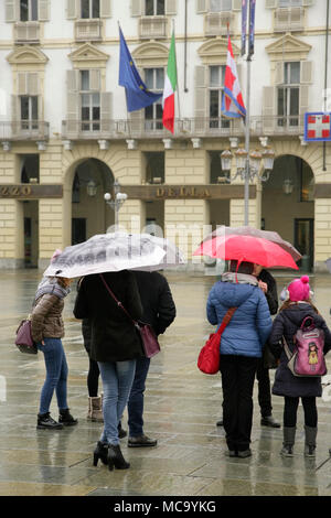 Les touristes avec des parasols sur jour de pluie sur la Piazza Castello, Turin, Italie. Banque D'Images