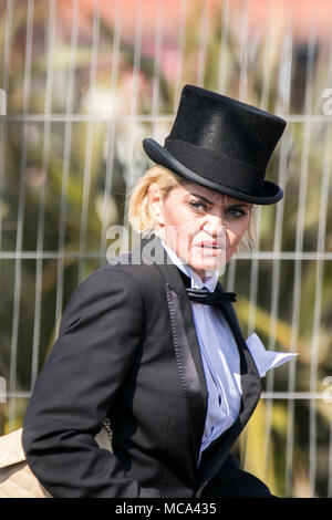 , Aintree Liverpool, Merseyside. 14 avril 2018. Un furieux Daniella Westbrook essaie de se cacher derrière son entourage qu'elle visite le Grand National Randox en pleine page à tails penguin tenue. Credit : Cernan Elias/Alamy Live News Banque D'Images