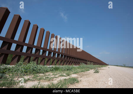 Une section de la clôture de sécurité entre les États-Unis et le Mexique se trouve au-dessus d'une digue de la rivière Rio Grande sur la côte du Texas de la frontière internationale dans la région de comté de Hidalgo. Banque D'Images