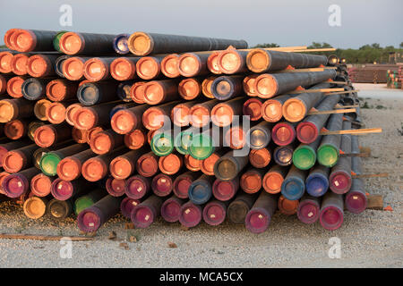 Tuyau de forage avec embouts colorés empilés siéger dans une cour près de l'autoroute 16 près des champs pétroliers dans le schiste d'Eagle Ford jouer dans McMullin County, au sud de San Antonio, Texas. Banque D'Images